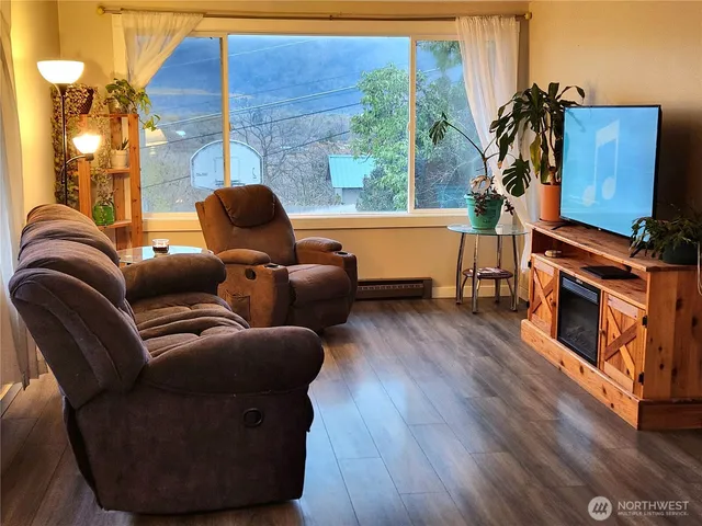a living room with furniture a window and wooden floor