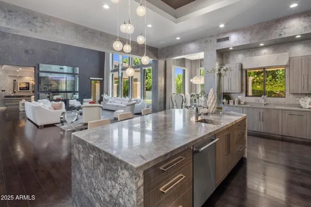 a kitchen with kitchen island granite countertop a sink stainless steel appliances and cabinets