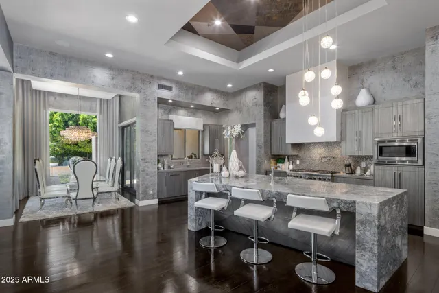 a kitchen with kitchen island granite countertop a sink stainless steel appliances and cabinets
