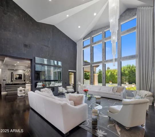 a living room with furniture kitchen area and a large window