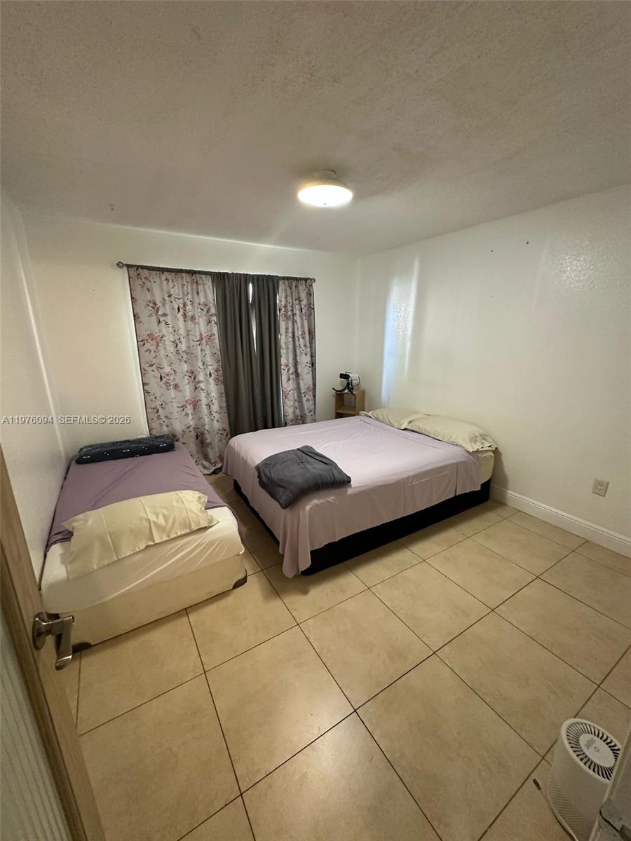 15640 Southwest 106th Lane, Unit 903 Miami, FL 33196 - Photo 8 of 8 a bedroom with a bed and window