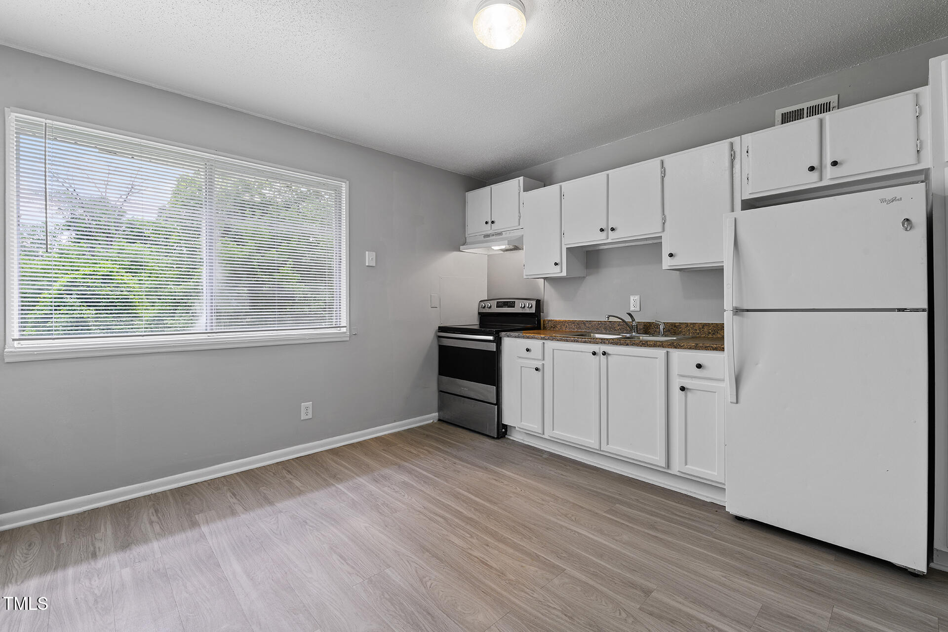 564 Dacian Road Raleigh, NC 27610 - Photo 3 of 16 a kitchen with granite countertop white cabinets and white appliances