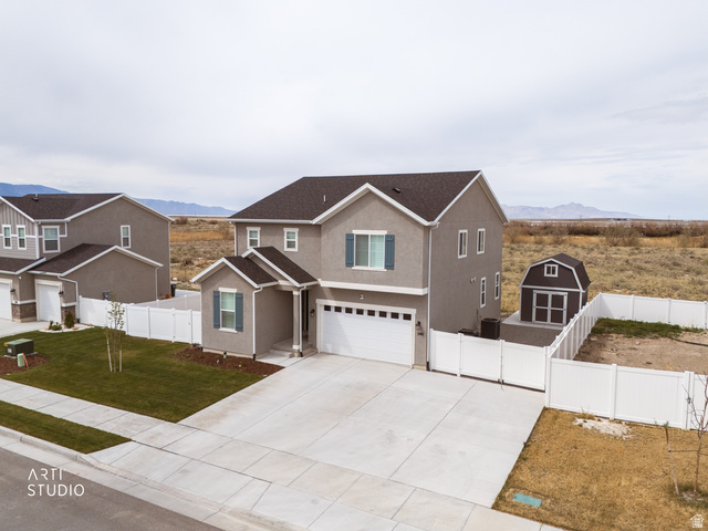 540 Lefty Lane Tooele, UT 84074 - Photo 45 of 48 Traditional-style house with a garage, concrete driveway, stucco siding, a mountain view, and a gate