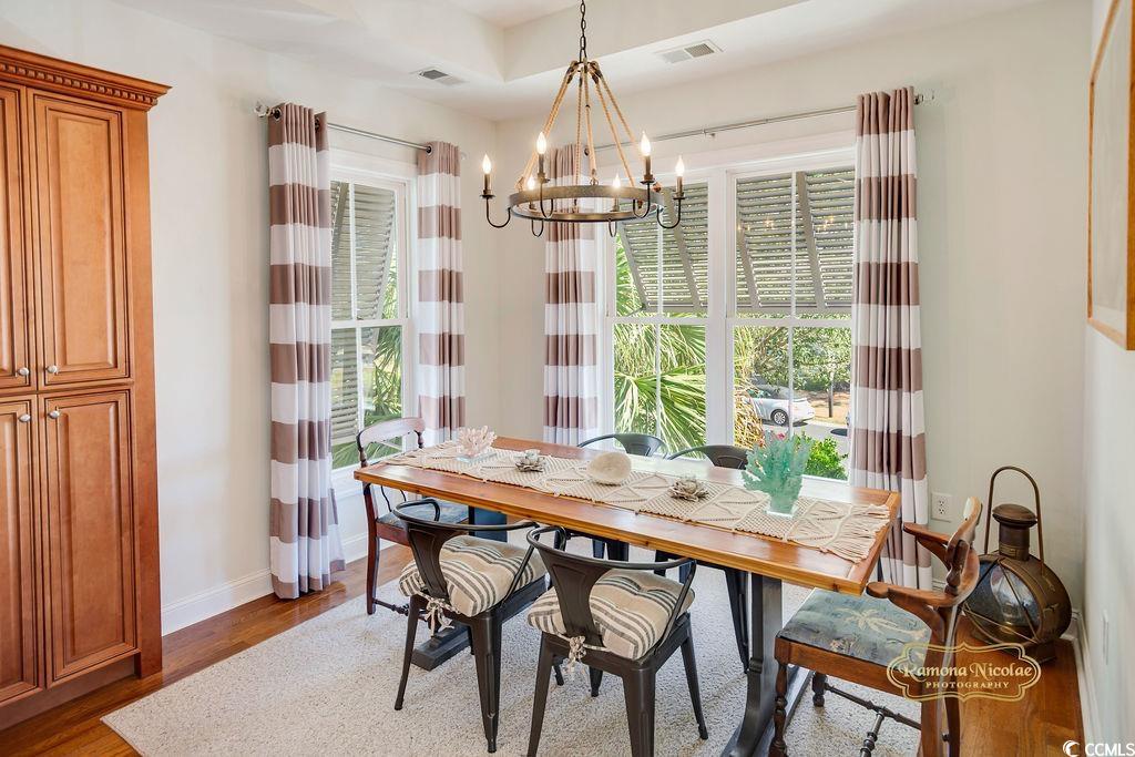 208 SummerWind Loop Murrells Inlet, SC 29576 - Photo 12 of 40 Dining space featuring a wealth of natural light, visible vents, an inviting chandelier, and wood finished floors