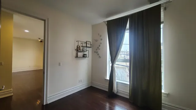 an empty room with wooden floor and a window