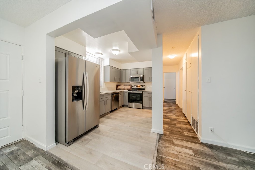 6979 Palm Court, Unit 319F Riverside, CA 92506 - Photo 14 of 44 a view of a kitchen with kitchen island wooden floor center island and stainless steel appliances