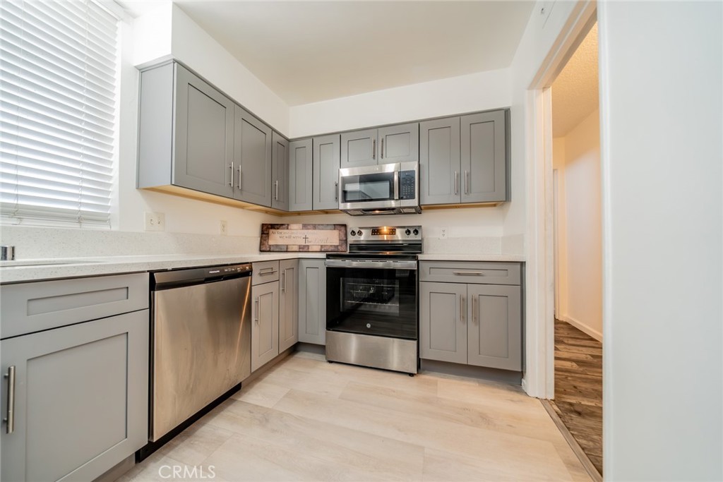 6979 Palm Court, Unit 319F Riverside, CA 92506 - Photo 16 of 44 a kitchen with stainless steel appliances granite countertop a stove and a sink