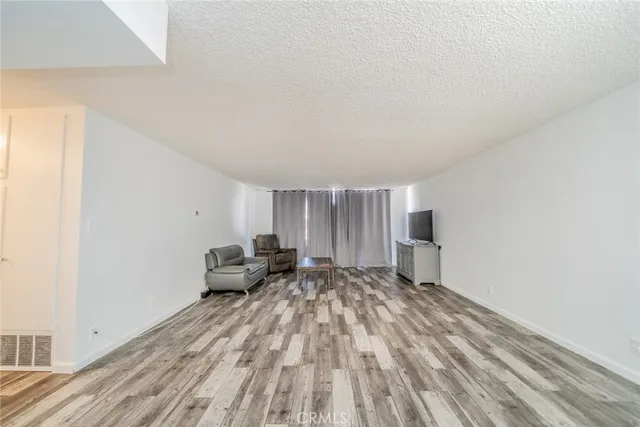 a living room with furniture a window and a wooden floor