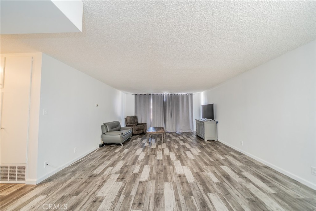 6979 Palm Court, Unit 319F Riverside, CA 92506 - Photo 6 of 44 a view of a bedroom with a bed and wooden floor