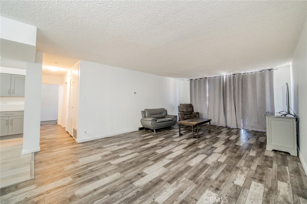 6979 Palm Court, Unit 319F Riverside, CA 92506 - Photo 7 of 44 a living room with furniture a window and a wooden floor