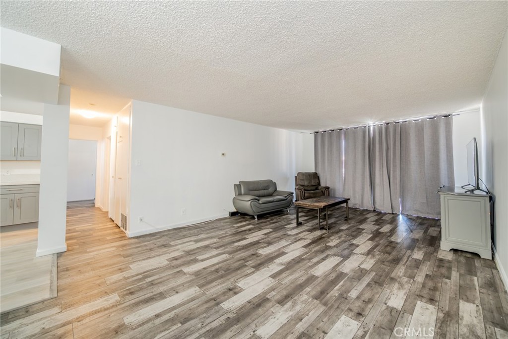 6979 Palm Court, Unit 319F Riverside, CA 92506 - Photo 7 of 44 a living room with furniture a window and a wooden floor