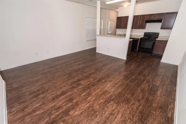 a kitchen with stainless steel appliances wooden floor and a sink