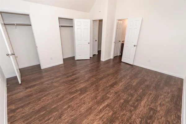 an empty room with wooden floor and entrance