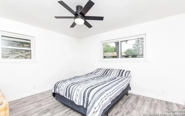 a bedroom with bed and wooden floor