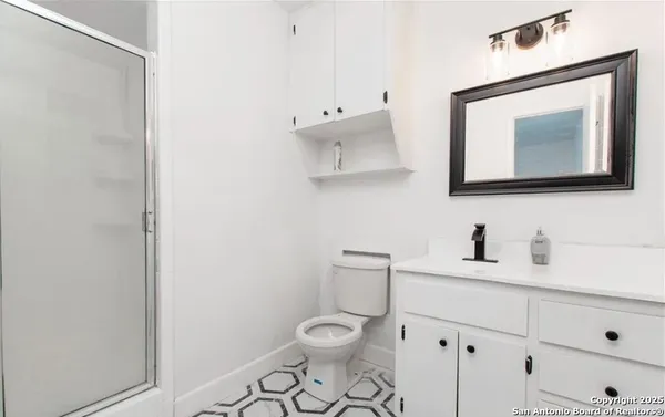 a bathroom with a toilet a sink and mirror