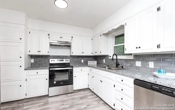 a kitchen with granite countertop a white cabinets and sink