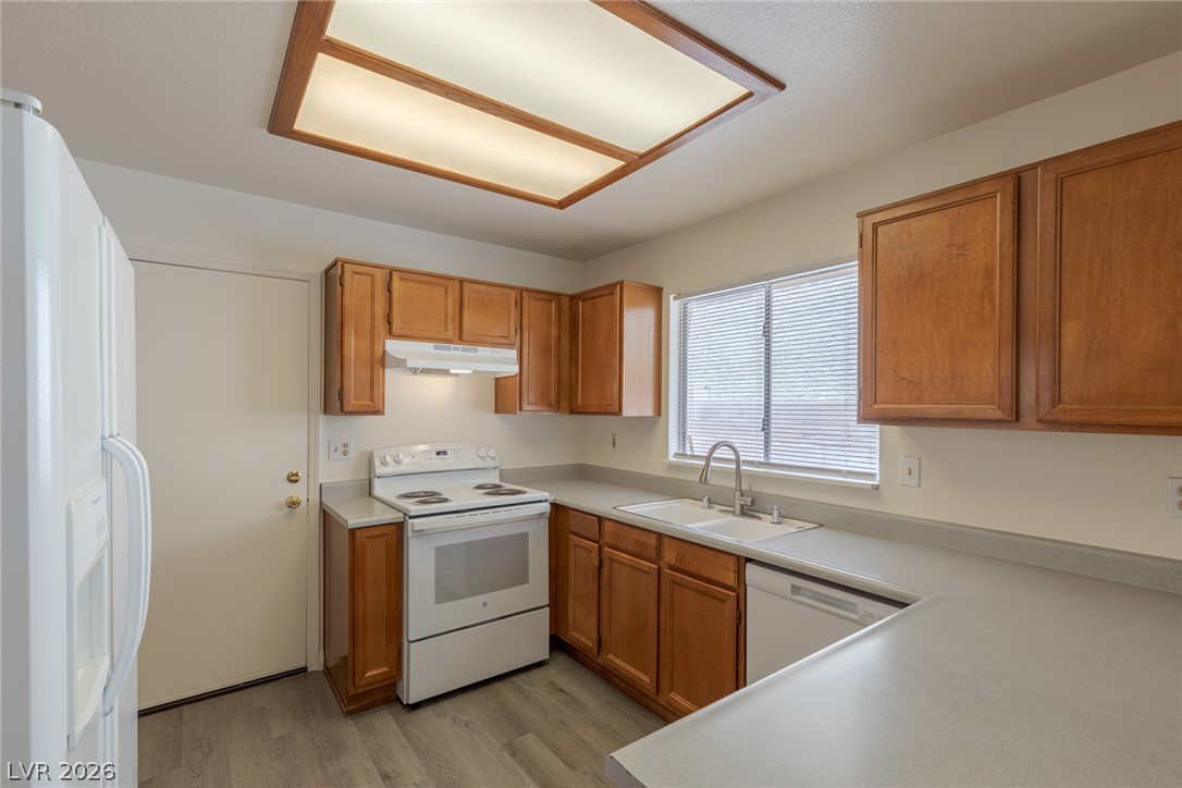 2803 Mirage Road Henderson, NV 89074 - Photo 14 of 39 Warm wood cabinetry and durable vinyl flooring define this functional kitchen workspace.