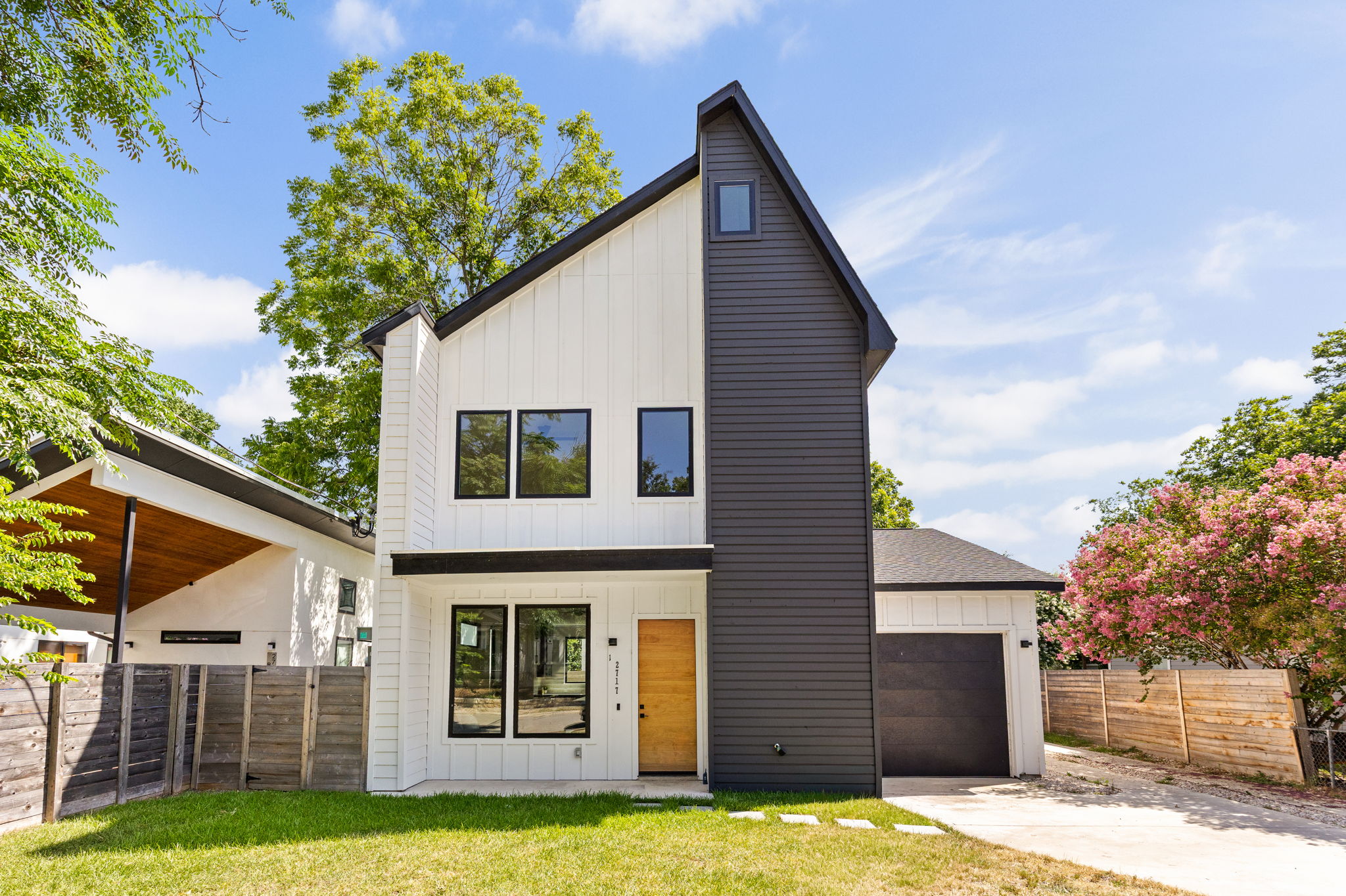 2717 Lyons Road, Unit 1 Austin, TX 78702 - Photo 1 of 40 Modern home with clean lines and contrasting dark and light siding, featuring a welcoming wooden front door.