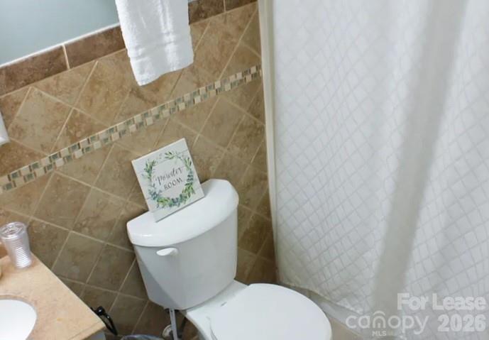 2027 Pimpernel Road Charlotte, NC 28213 - Photo 11 of 12 a white toilet sitting next to a shower curtain