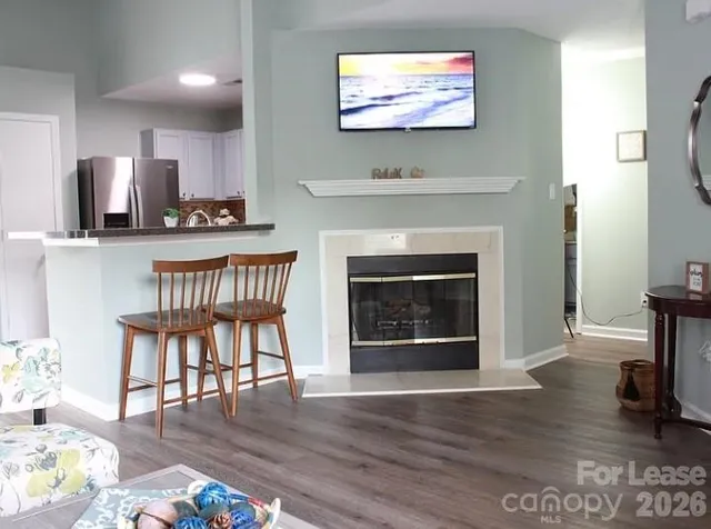 a living room with furniture a fireplace and flat screen tv