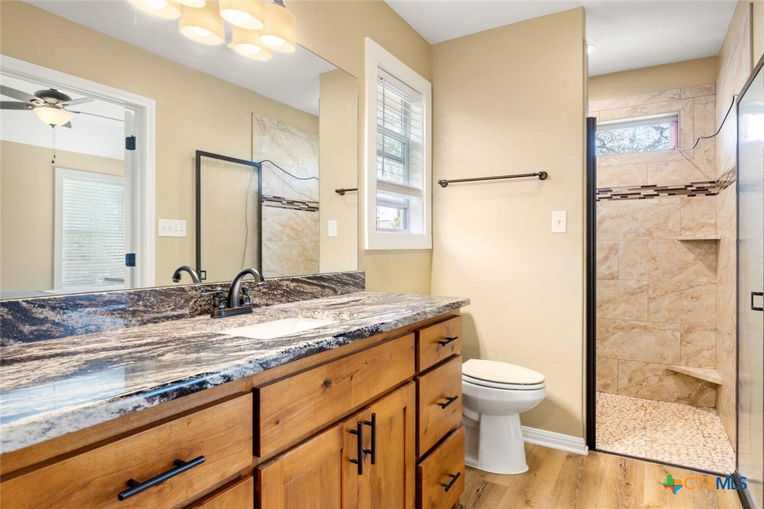 1306 Live Oak Drive Spring Branch, TX 78070 - Photo 11 of 18 a bathroom with a granite countertop sink toilet and shower