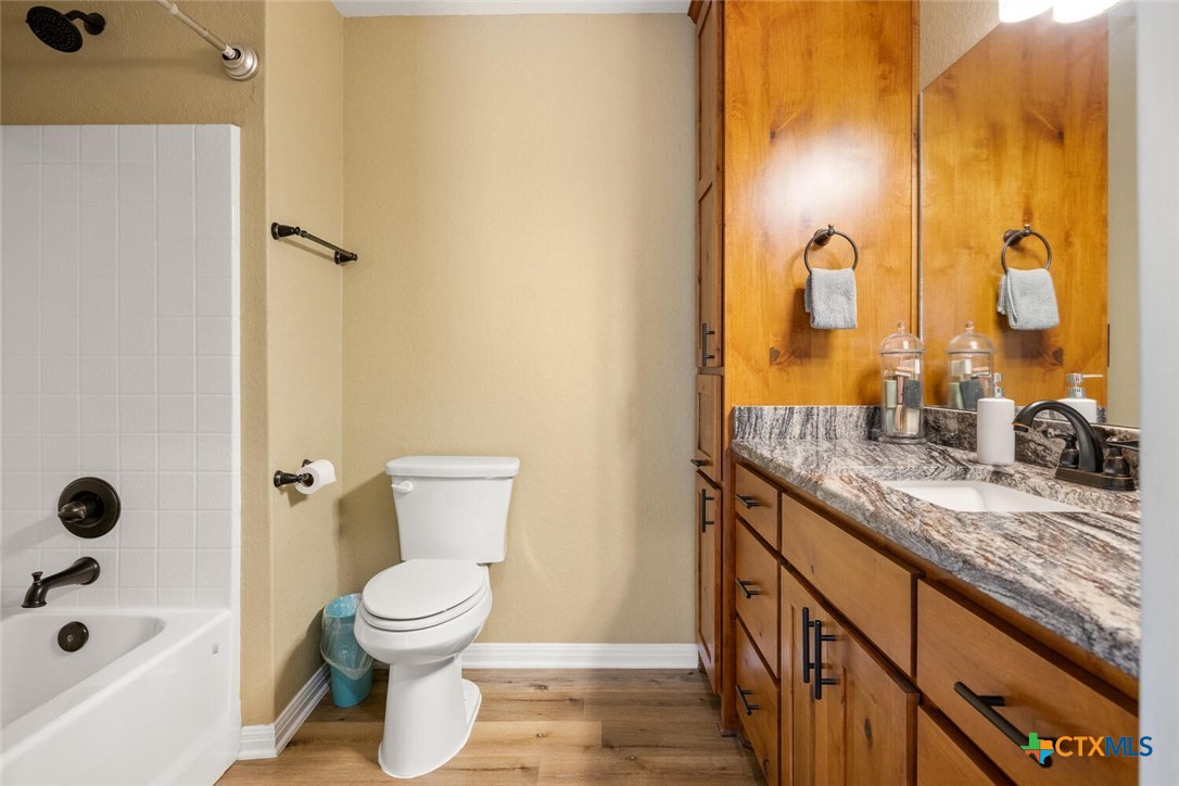 1306 Live Oak Drive Spring Branch, TX 78070 - Photo 14 of 18 a bathroom with a granite countertop sink toilet and shower