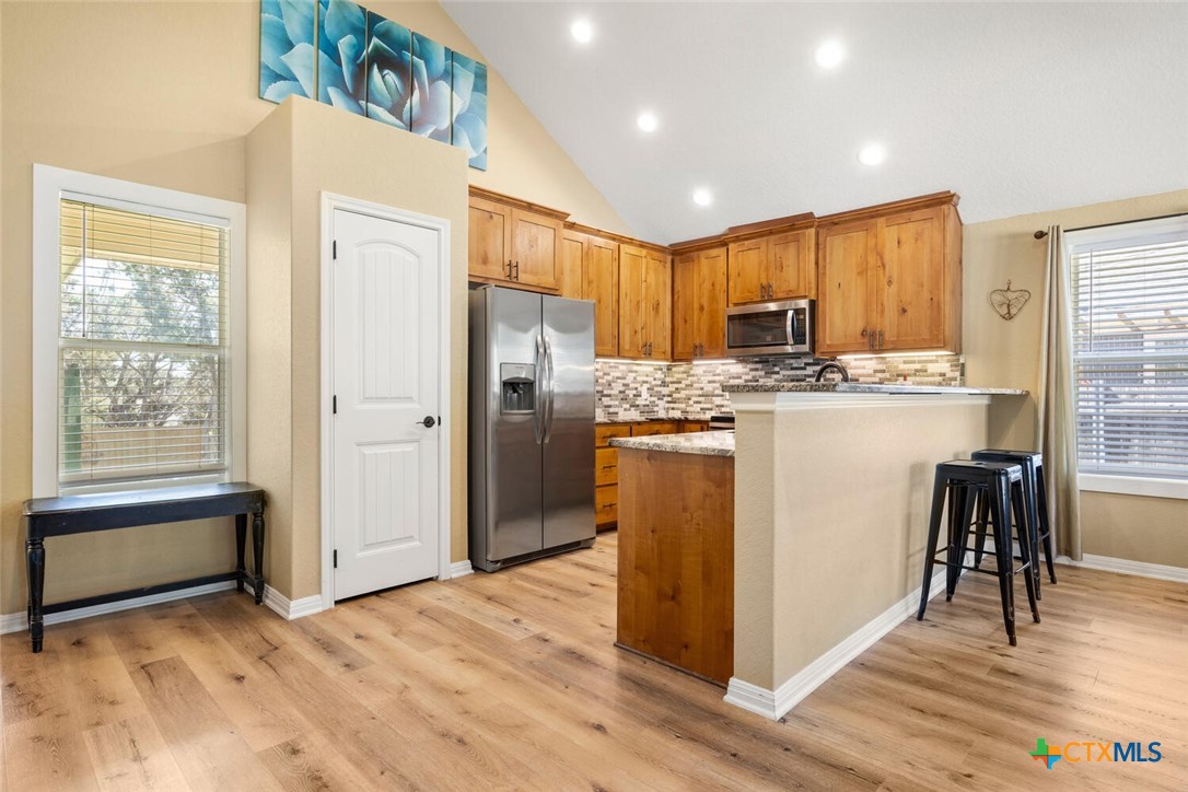 1306 Live Oak Drive Spring Branch, TX 78070 - Photo 8 of 18 a kitchen with stainless steel appliances granite countertop a refrigerator a stove a sink and a microwave