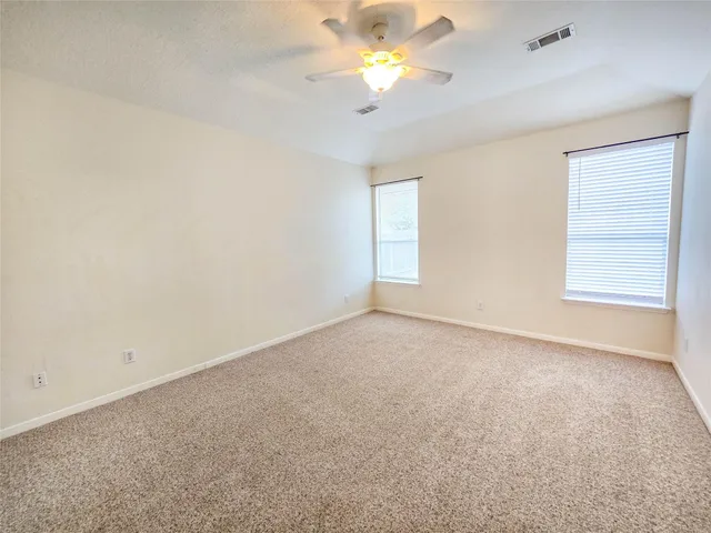 an empty room with a window and a ceiling fan
