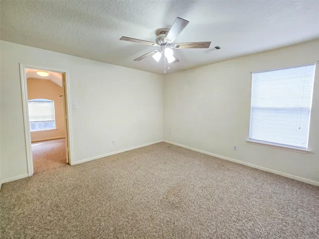 an empty room with a fan and a window