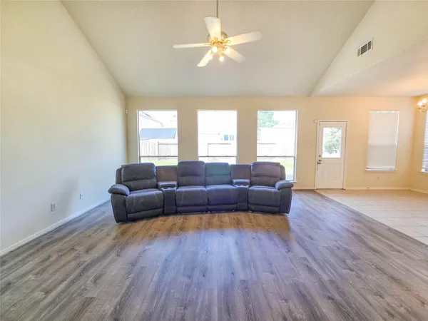 a living room with furniture and a wooden floor