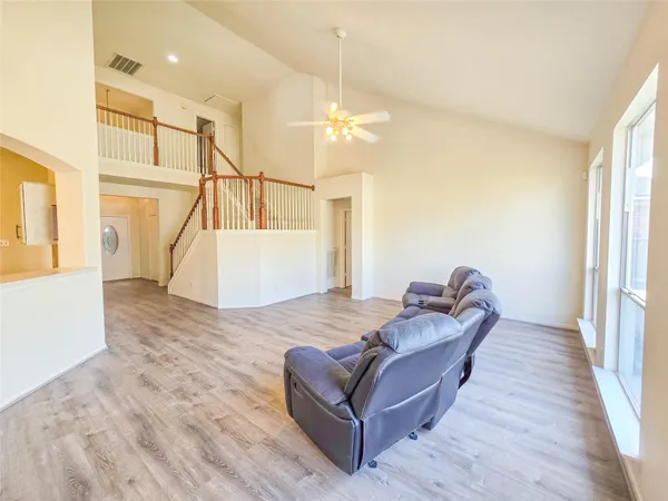 a living room with furniture and a wooden floor