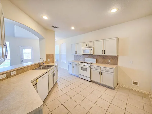 a large kitchen with a sink and cabinets