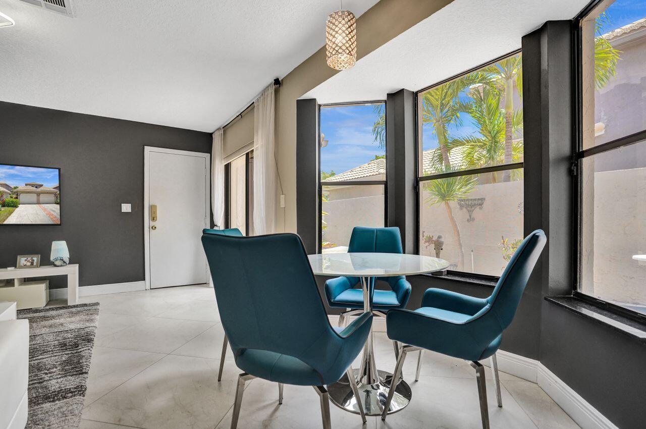 5465 Monterey Circle, Unit D Delray Beach, FL 33484 - Photo 32 of 67 a view of a dining room with furniture a rug and wooden floor