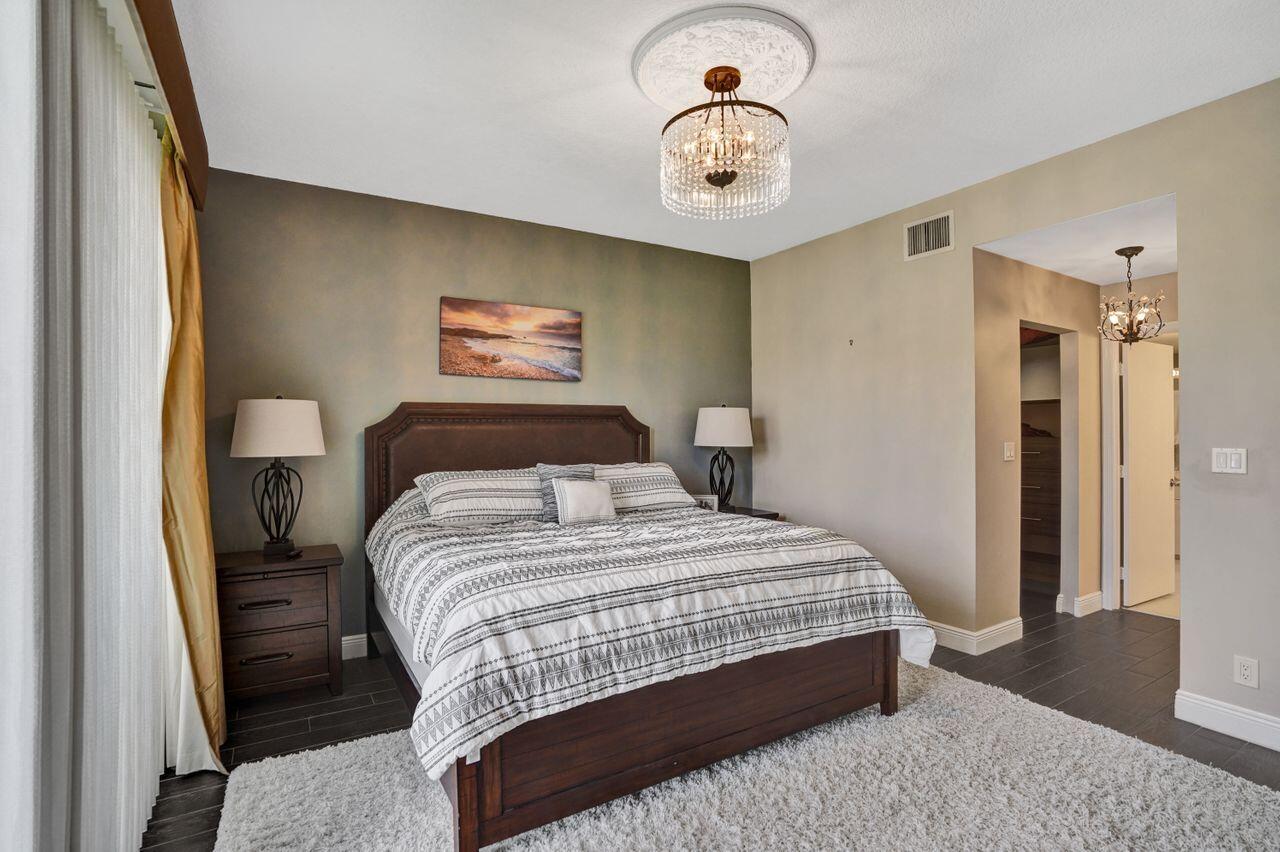 5465 Monterey Circle, Unit D Delray Beach, FL 33484 - Photo 38 of 67 a bedroom with a bed and wooden floor
