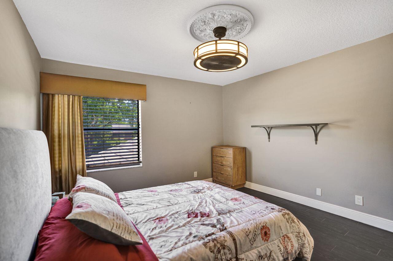 5465 Monterey Circle, Unit D Delray Beach, FL 33484 - Photo 52 of 67 a bedroom with a bed and a window