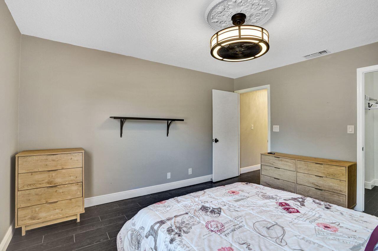 5465 Monterey Circle, Unit D Delray Beach, FL 33484 - Photo 53 of 67 a bedroom with a bed and a dresser