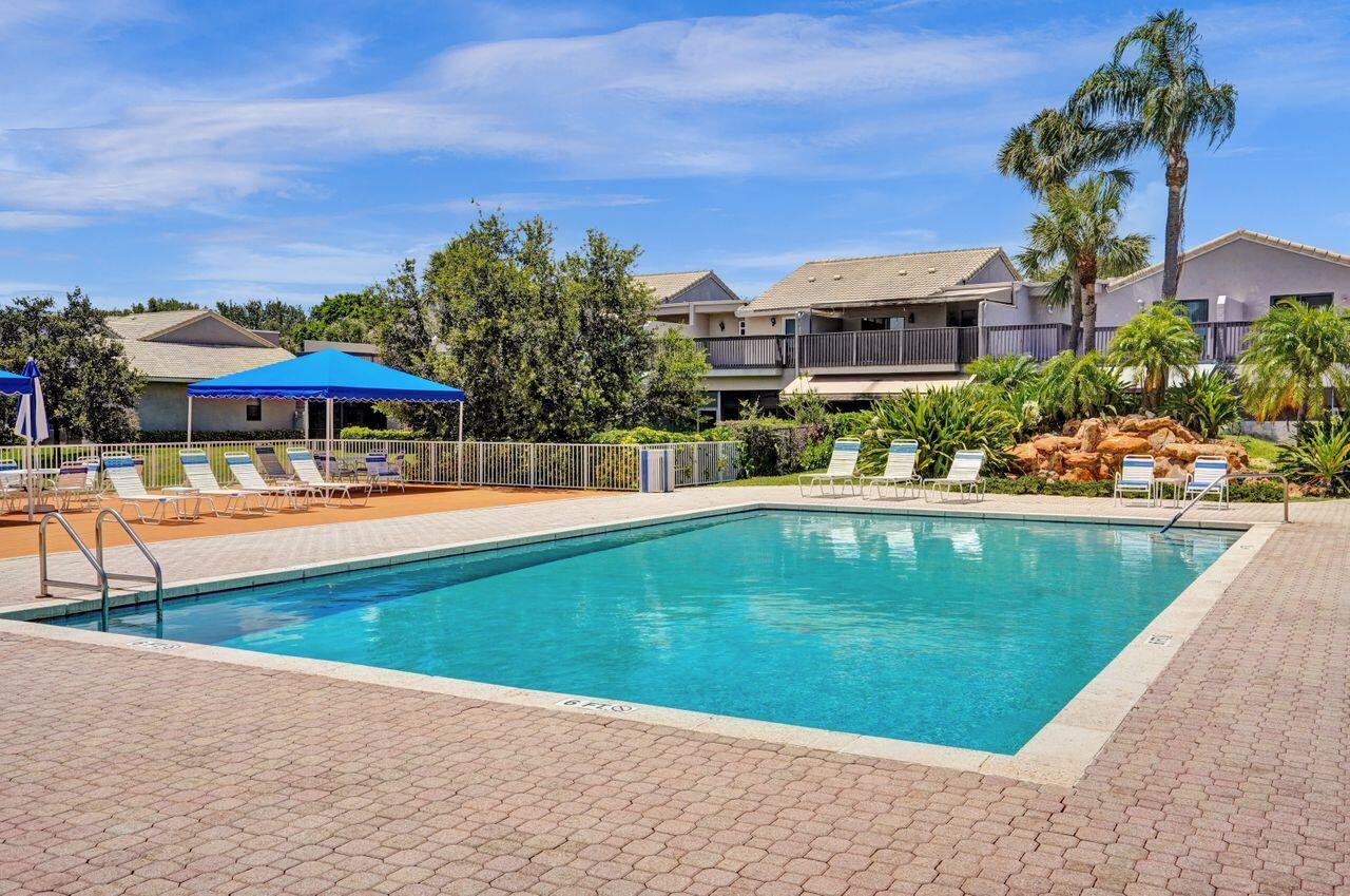 5465 Monterey Circle, Unit D Delray Beach, FL 33484 - Photo 62 of 67 a view of a swimming pool with an outdoor seating
