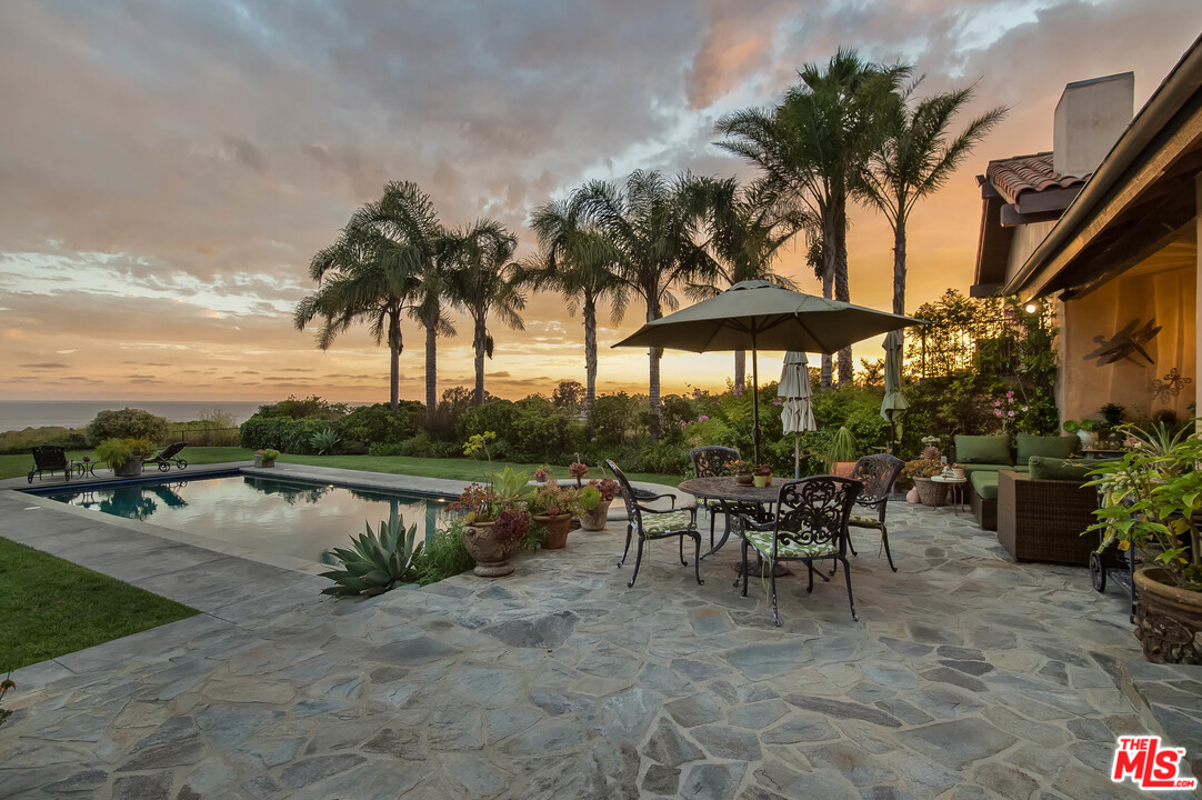 29660 Harvester Road Malibu, CA 90265 - Photo 1 of 32 a view of a tables and chairs under an umbrella