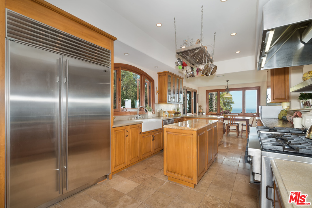 29660 Harvester Road Malibu, CA 90265 - Photo 14 of 32 a kitchen with stainless steel appliances granite countertop a sink a stove and a refrigerator