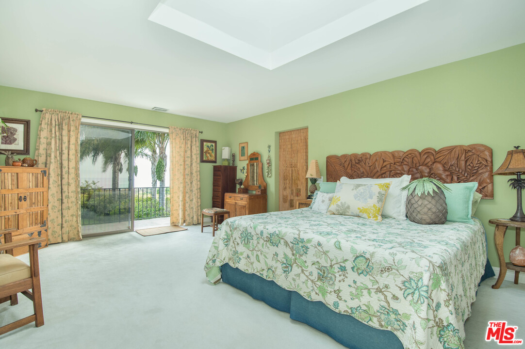 29660 Harvester Road Malibu, CA 90265 - Photo 19 of 32 a spacious bedroom with a bed and glass door