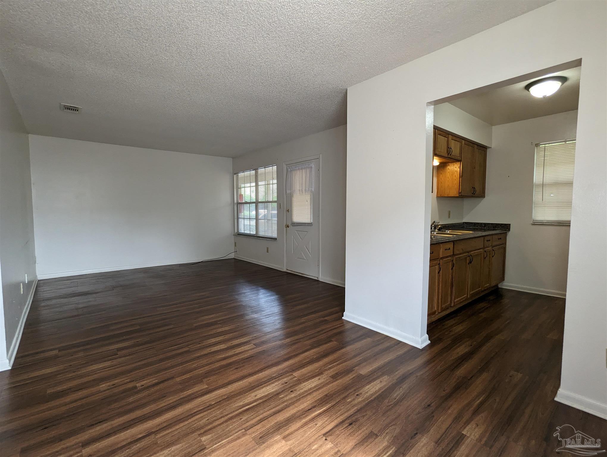 6288 Hamilton Bridge Road, Unit 301 Milton, FL 32570 - Photo 7 of 24 wooden floor in an empty room with a window