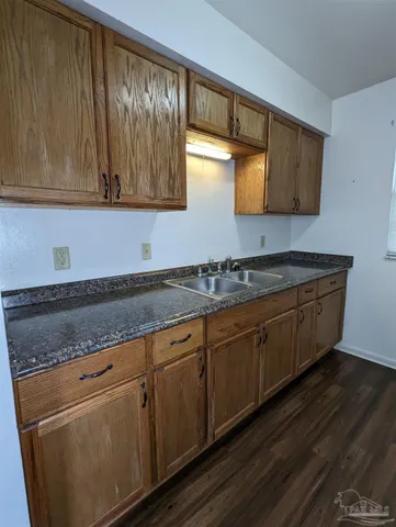 a kitchen with granite countertop wooden cabinets and sink