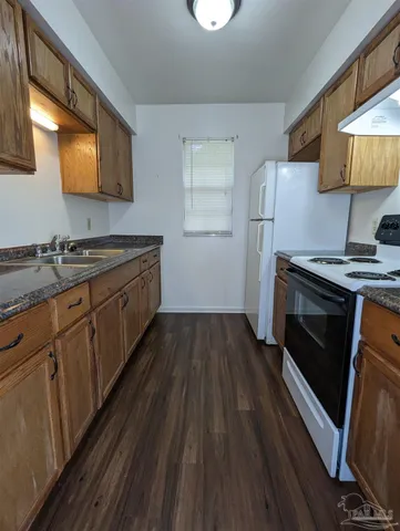 a kitchen with wooden floors wooden cabinets and stainless steel appliances