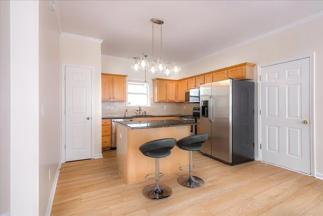 a kitchen with stainless steel appliances granite countertop a refrigerator and a stove top oven