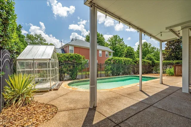a backyard with table and chairs and potted plants