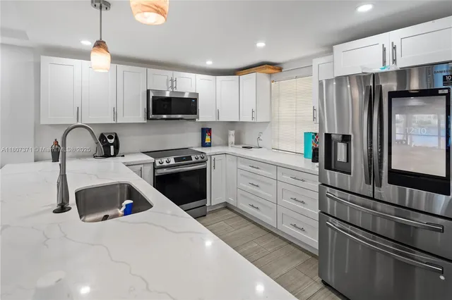 a kitchen with a sink appliances and cabinets
