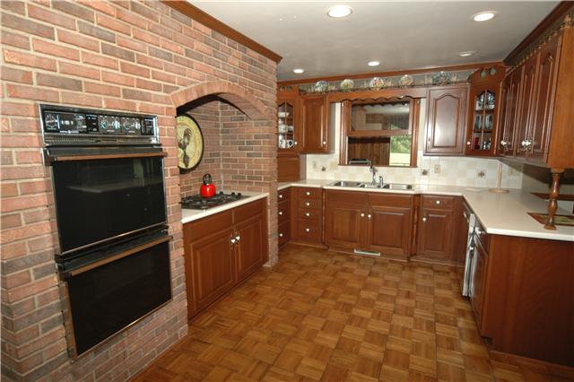 Country Kitchen has double ovens, gas cooktop, solid surface countertops and recessed lighting.