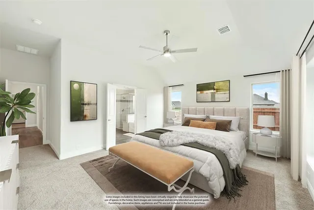 a spacious bedroom with a bed a couch and a potted plant