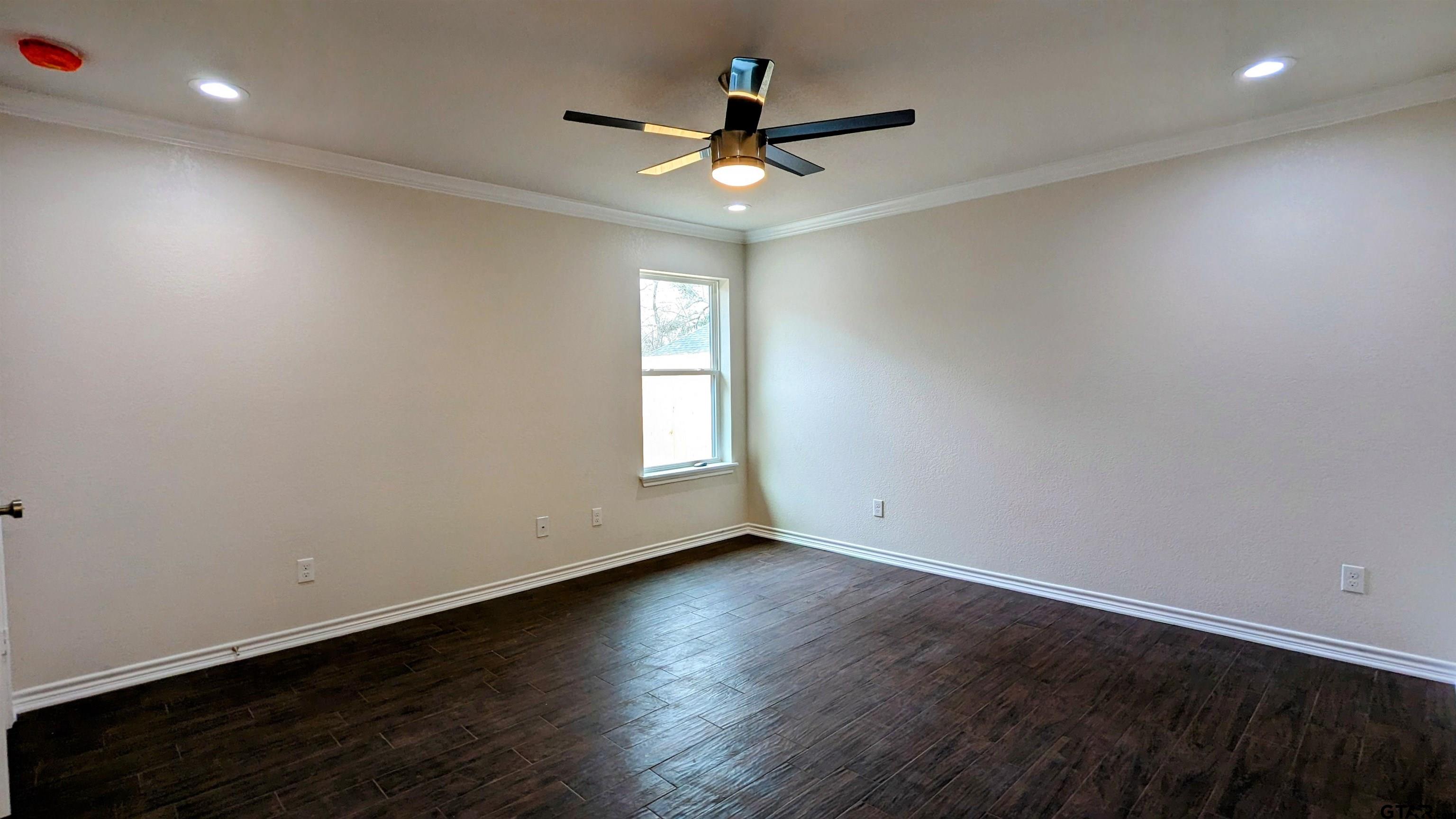 11086 County Road 167, Unit 11 Tyler, TX 75703 - Photo 10 of 20 an empty room with wooden floor and windows