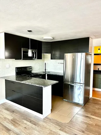 a kitchen with kitchen island a counter top space cabinets and stainless steel appliances